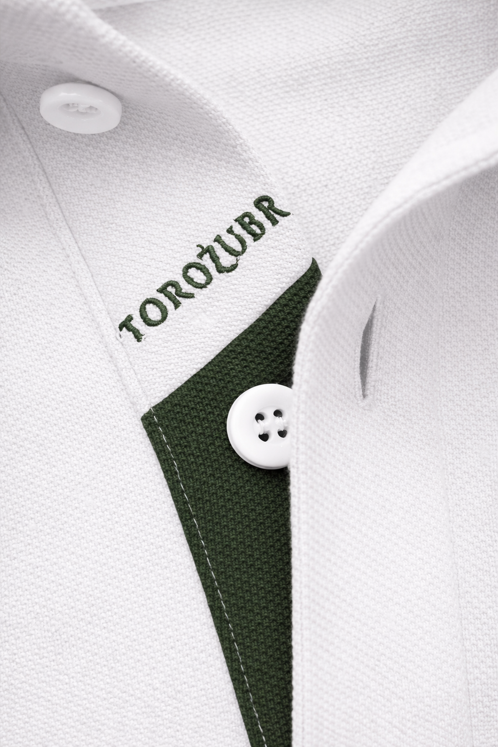 Close-up of a white polo placket with grey trim and 'TOROZUBR' branding.