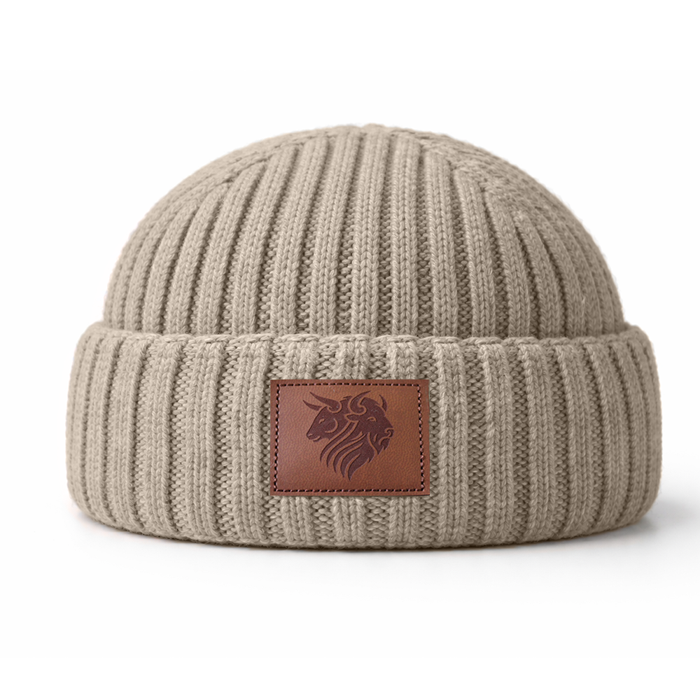 Beige knit beanie with a brown leather patch featuring ToroZubr logo on a white background